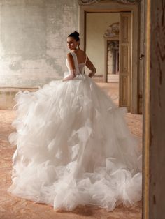 a woman in a white wedding dress is posing for the camera