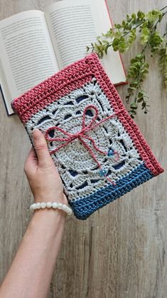 a person is holding an open book with crochet on it and the pages are red white and blue