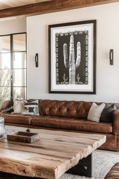 a living room with leather couches and a wooden coffee table in front of a window