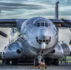 an airplane is parked on the tarmac with its wheels down and people around it