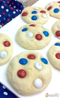 cookies decorated with red, white and blue candies are on a plate next to a polka dot table cloth