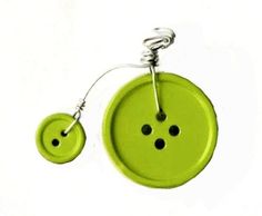 a lime green button with two black buttons attached to it's side, hanging from a silver wire