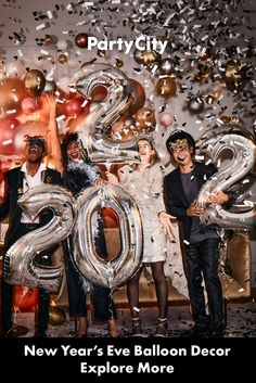 a group of people standing next to each other in front of balloons and confetti