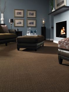 a living room with two couches and a fire place in the fireplace, surrounded by pictures on the wall