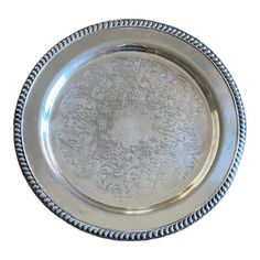 an ornate silver plate with beaded edges on a white background is seen in this image