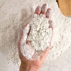 a person's hand is covered in powdered sugar on top of white flour