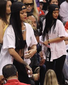 two women standing next to each other at a basketball game