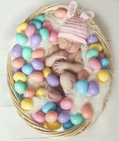 a baby is laying in a basket filled with eggs