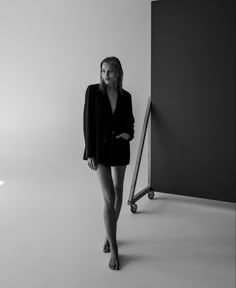 a woman is standing in front of a black and white photo with her legs crossed