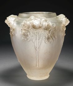 a white vase with flowers and trees on it