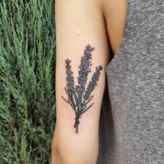 a woman's arm with a lavender tattoo on it