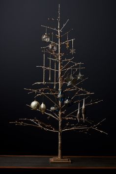 a christmas tree with ornaments hanging from it's branches in front of a black background