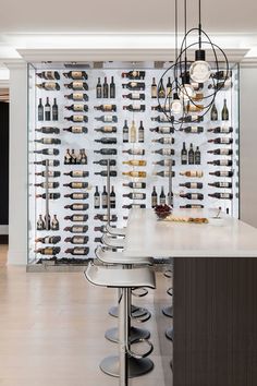 a wine rack in the middle of a room with several bottles hanging on the wall