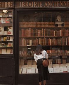 a woman standing in front of a book store