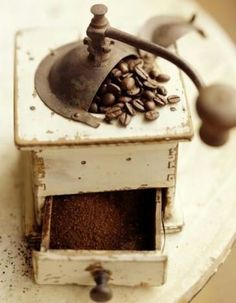 an old fashioned coffee grinder with beans in it