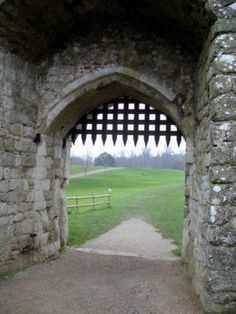 an archway leading to a grassy field