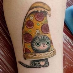 a cat with a slice of pizza on it's head is sitting in front of a tattoo