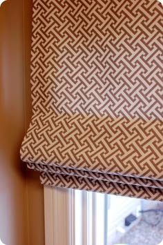 a close up of a window with a roman blind in the middle and an intricate pattern on it