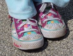 a child's feet wearing pink and blue sneakers