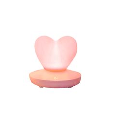 a pink heart shaped light sitting on top of a white surface with an orange base