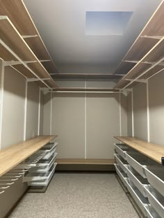 an empty storage room with wooden shelves and drawers