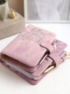 three pink notebooks sitting on top of each other