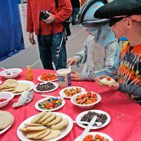 a man in a cowboy hat sitting at a table with plates of food on it