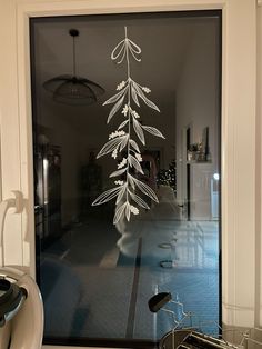 a bicycle parked in front of a glass door with a white tree drawn on it