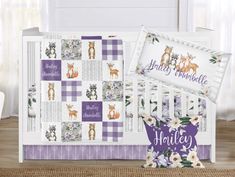 a baby crib bedding set with purple and white animals on it, next to the crib