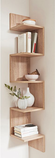 the shelves are made out of wood and have books on each shelf, as well as vases