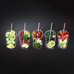 a row of fruit cups with strawberries, kiwis, lemons, limes and watermelon