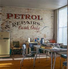 the interior of a repair and cash only shop with an old refrigerator in front of it