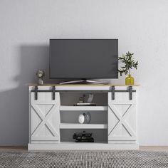 a flat screen tv sitting on top of a white entertainment center