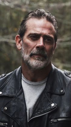 a man in a leather jacket looking at the camera