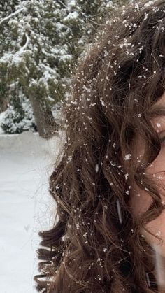 a woman standing in the snow blowing her hair