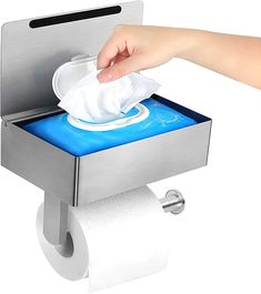 a hand holding a tissue dispenser over a roll of toilet paper in a holder