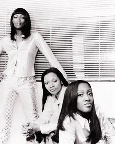 three women in white outfits posing for a photo