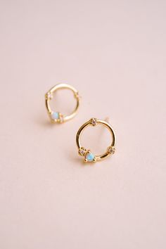 Brighten up your look with the Orbital Glow Opal Studs! These stunning studs feature man-made opal stones set in a 14k gold-plated circular design with sparkling cubic zirconia accents. The combination of opal and gold creates a timeless accessory that adds a touch of sophistication to any outfit. Why do we love these? They are super versatile and can work with every style and outfit! EARRINGS FEATURE Material: Brass, Man-Made Opal Stone Dimensions/Size: 8.5.mm Diameter, 1.1mm opal stone Finish: Opal Earrings Gold, Opal And Gold Earrings, Opal Stud Earring, Elegant Adjustable Opal Earrings, Opal Earring, Circular Design, Opal Earrings Stud, Opal Studs, Opal Stone