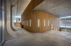 a person walking in an empty room with wooden slats on the walls and floor