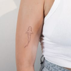 a woman's arm with a tattoo on it that is shaped like a seahorse