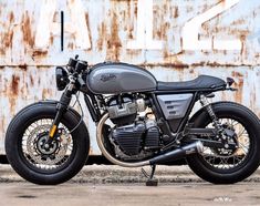 a motorcycle parked in front of a rusted wall