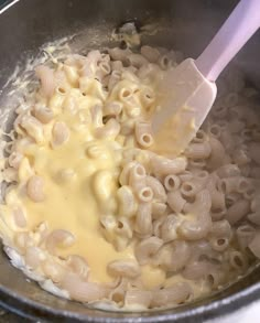 macaroni and cheese being stirred in a pot