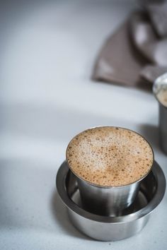 two cups of coffee sitting next to each other on a table