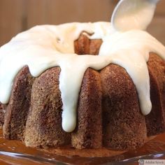 a bundt cake with white icing on a glass platter, ready to be eaten