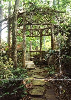 a bench sitting under a wooden arbor in the woods