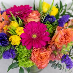 a vase filled with lots of colorful flowers