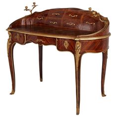 19th century French Louis XV style ormolu mounted writing desk French, Late 19th Century Height 100cm, width 121cm, depth 66cm Crafted in the late 19th century, this writing desk is filled with Louis XV style decorative features. Of an elongated oval outline with a shaped bombe structure, the writing desk is filled with several storage compartments. The upper part of the pieces features four tapering drawers flanked by two larger ones. Each one is mounted with rocaille-shaped ormolu handles. The Vintage Writing Desk, Antique Writing Desk, House Interior Design Styles, Antique Restoration, Desk Writing, Table 19, Roll Top Desk, Carriage Clocks, Elongated Oval