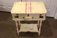 an old suitcase turned into a side table with pink trimmings on the top