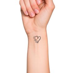 a woman's arm with a small heart tattoo on the left side of her wrist