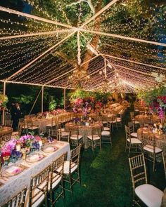 the inside of a tent with tables and chairs set up for an outdoor wedding reception